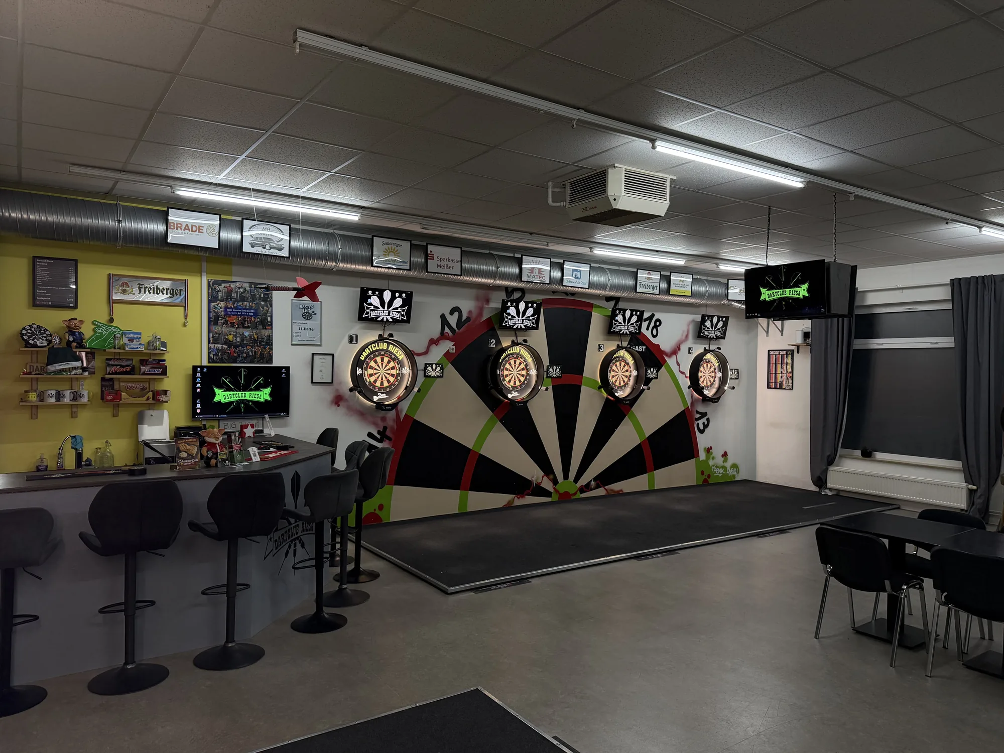 Gesamtansicht der Spielstätte des Dartclub Riesa mit Dartboards, Theke und Sitzbereich